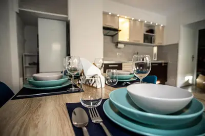 a dining room table with plates and wine glasses at Charmant 2p proche des plages, appartement Céladon in Cannes