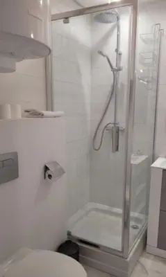 a white bathroom with a shower and a toilet at Centre Cannes Victor Cousin in Cannes