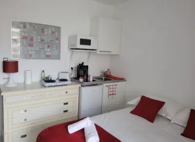 a small kitchen with a couch and a microwave at Centre Cannes Victor Cousin in Cannes