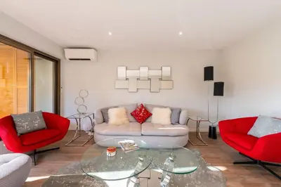 a living room with a couch and two red chairs at Beautiful 2-Br Apartment Sea View Beaches Within Walking Distance in Cannes