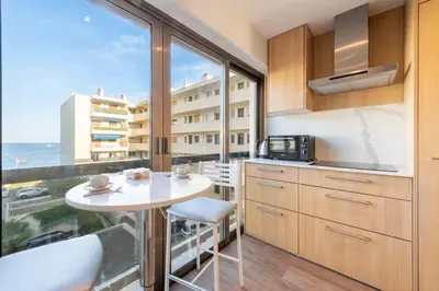 a kitchen with a table and a large window at Beautiful 2-Br Apartment Sea View Beaches Within Walking Distance in Cannes