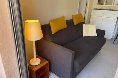 a brown couch in a living room with a lamp at Apartment for 2 with balcony near beach in Cannes