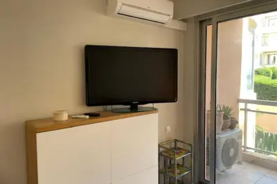 a flat screen tv sitting on top of a white cabinet at Apartment for 2 with balcony near beach in Cannes