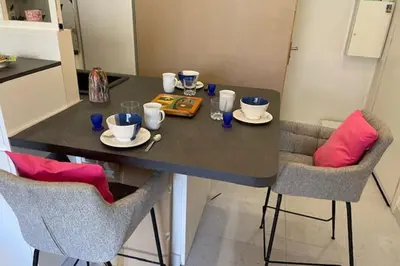 a dining room table with two chairs and a black table at Apartment for 2 with balcony near beach in Cannes