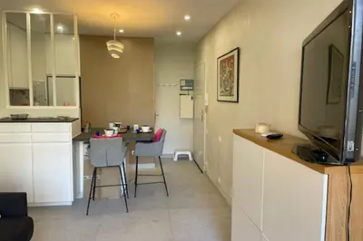 a kitchen and living room with a table and chairs at Apartment for 2 with balcony near beach in Cannes