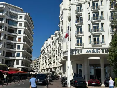 a tall white building with a sign on it at Adresse privilège pour les congres in Cannes