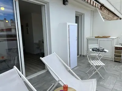 a white bedroom with a bed and a living room at Adresse privilège pour les congres in Cannes