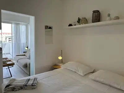 a white bed in a bedroom with a door at Adresse privilège pour les congres in Cannes