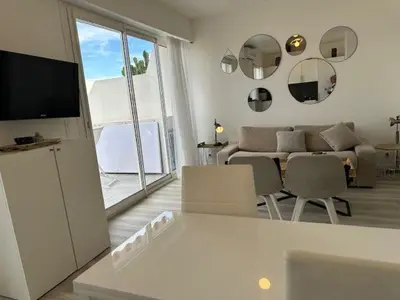 a living room with a television and a living room with a couch at Adresse privilège pour les congres in Cannes