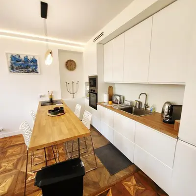 a kitchen with a wooden table and white cabinets at Exceptional 3-room apartment in quiet Cannes in Cannes