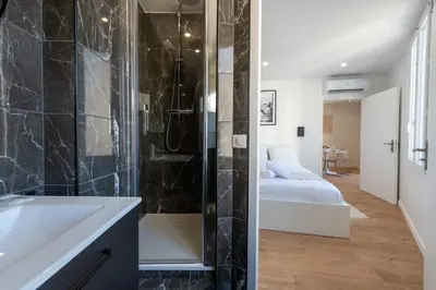 a bathroom with a shower and a sink and a bed at Cannes 1-Br Apartment Near the City Center in Cannes