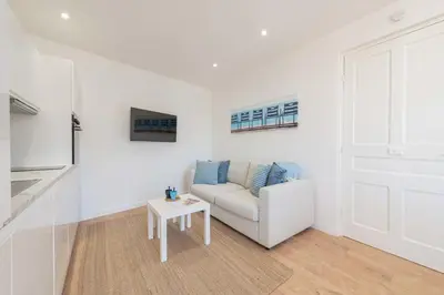 a white living room with a couch and a table at Cannes 1-Br Apartment Near the City Center in Cannes
