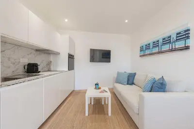 a white living room with a couch and a table at Cannes 1-Br Apartment Near the City Center in Cannes