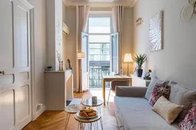 a living room with a couch and a table at Parthenopi suite, le chic de Cannes dans le centre, près du palais in Cannes