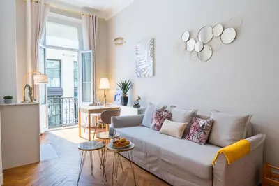 a living room with a couch and a table at Parthenopi suite, le chic de Cannes dans le centre, près du palais in Cannes