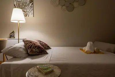 a bed with a stuffed animal sitting on top of it at Parthenopi suite, le chic de Cannes dans le centre, près du palais in Cannes