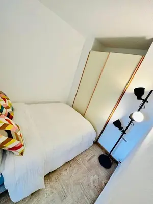 a small bedroom with a bed and a lamp at Le 65 Picaud - Superbe logement proche plages in Cannes