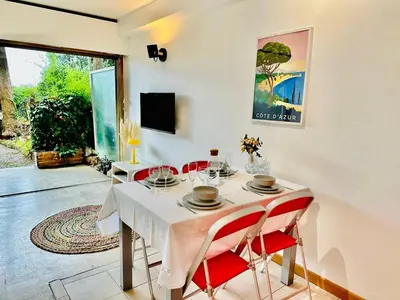 a dining room with a white table and red chairs at Le 65 Picaud - Superbe logement proche plages in Cannes