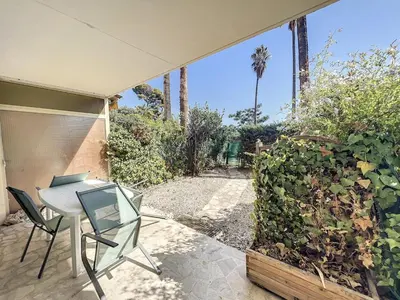 a patio with a table and chairs and a plant at Le 65 Picaud - Superbe logement proche plages in Cannes
