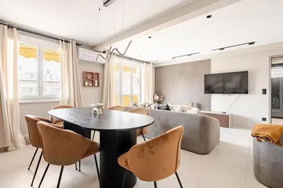 a living room with a couch and a table and chairs at LX169 Design lumineux a deux pas de la Croisette in Cannes
