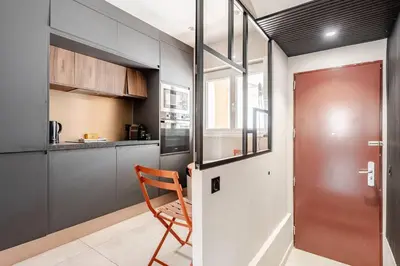 a kitchen with a red door and a chair at LX169 Design lumineux a deux pas de la Croisette in Cannes