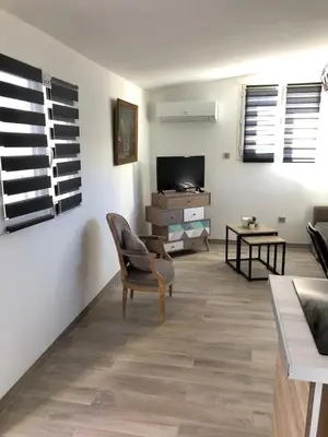 a living room with a chair and a television at Charming 38m2 city house in Le Cannet