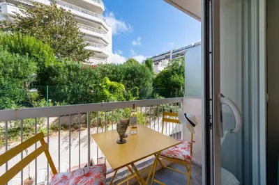 a balcony with a table and a bottle of wine at 1-Br Apartment Quiet Setting Near City Center in Cannes