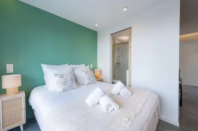 a bedroom with a white bed with towels on it at 1-Br Apartment Quiet Setting Near City Center in Cannes