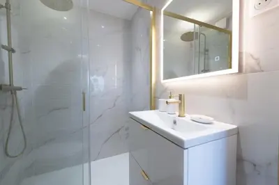 a white bathroom with a sink and a shower at 1-Br Apartment Quiet Setting Near City Center in Cannes