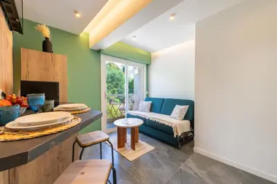 a living room with green walls and a blue couch at 1-Br Apartment Quiet Setting Near City Center in Cannes