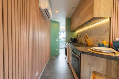 a kitchen with wooden walls and a counter with a sink at 1-Br Apartment Quiet Setting Near City Center in Cannes