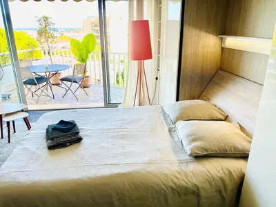 a bed in a room with a view of a patio at Grande studio, Vue mer magnifique in Cannes