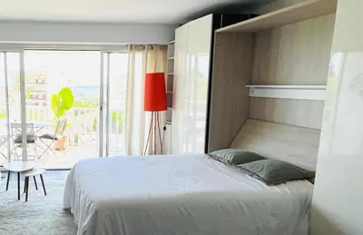 a bedroom with a bed and a view of a balcony at Grande studio, Vue mer magnifique in Cannes