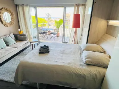 a bedroom with a bed and a living room with a couch at Grande studio, Vue mer magnifique in Cannes