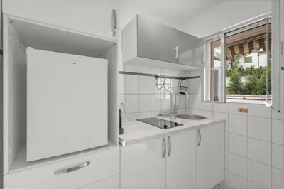a white kitchen with a sink and a window at Studio in Cannes city center with terrace in Cannes