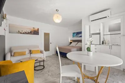 a living room with a white table and yellow chairs at Studio in Cannes city center with terrace in Cannes