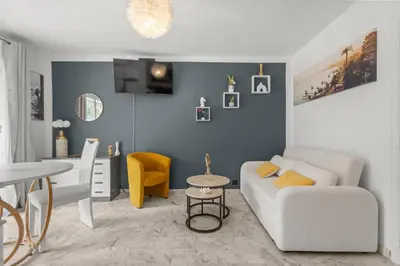 a living room with a white couch and a table at Studio in Cannes city center with terrace in Cannes