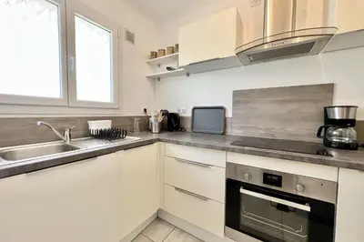 a kitchen with white cabinets and a sink at Beautiful T2 large terrace near Center & sea in Cannes