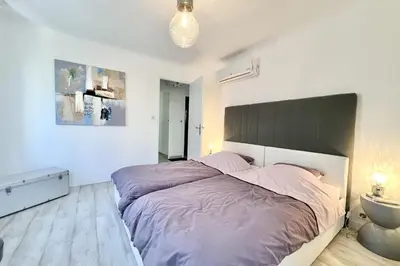 a bedroom with a large bed with a large headboard at Beautiful T2 large terrace near Center & sea in Cannes