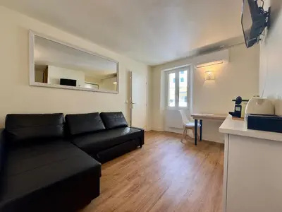 a living room with a black couch and a table at Le Laguna - SCLS Locations in Cannes