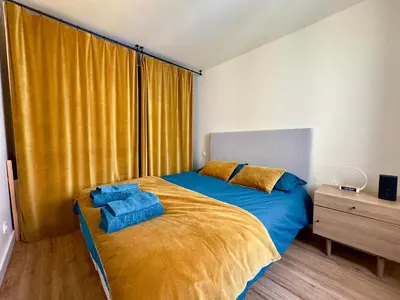 a bedroom with a bed with blue sheets and a window at Le Laguna - SCLS Locations in Cannes