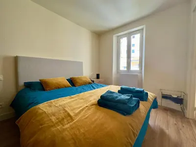 a bedroom with a large bed with blue sheets at Le Laguna - SCLS Locations in Cannes