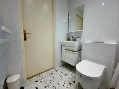 a white bathroom with a toilet and a mirror at Le Laguna - SCLS Locations in Cannes