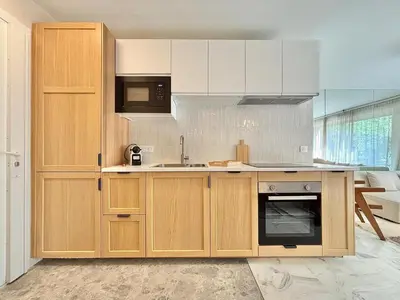 a kitchen with wooden cabinets and a sink at Cannes 2 bedrooms Apartment - MAD 20 in Cannes