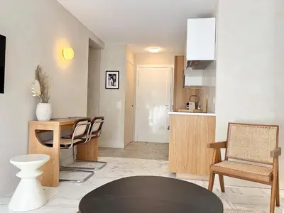 a living room with a table and chairs and a kitchen at Cannes 2 bedrooms Apartment - MAD 20 in Cannes