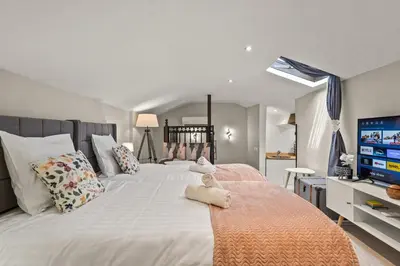 a bedroom with a large white bed with a flat screen tv at Studio Cannes city center in Cannes