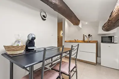 a kitchen with a table and chairs and a refrigerator at Studio Cannes city center in Cannes