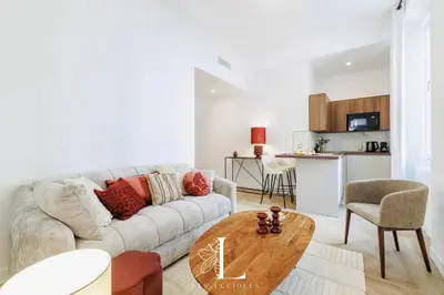 a living room with a couch and a table at Les Lucioles 1 - Luxury 1 Bedroom Apartment in Cannes