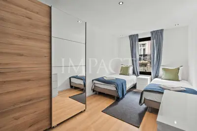 a bedroom with two beds and a mirror at REF 2014 - Cannes center - Apartment to rent in Cannes