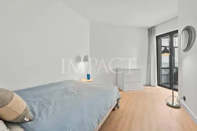 a white bedroom with a bed and a large window at REF 2014 - Cannes center - Apartment to rent in Cannes